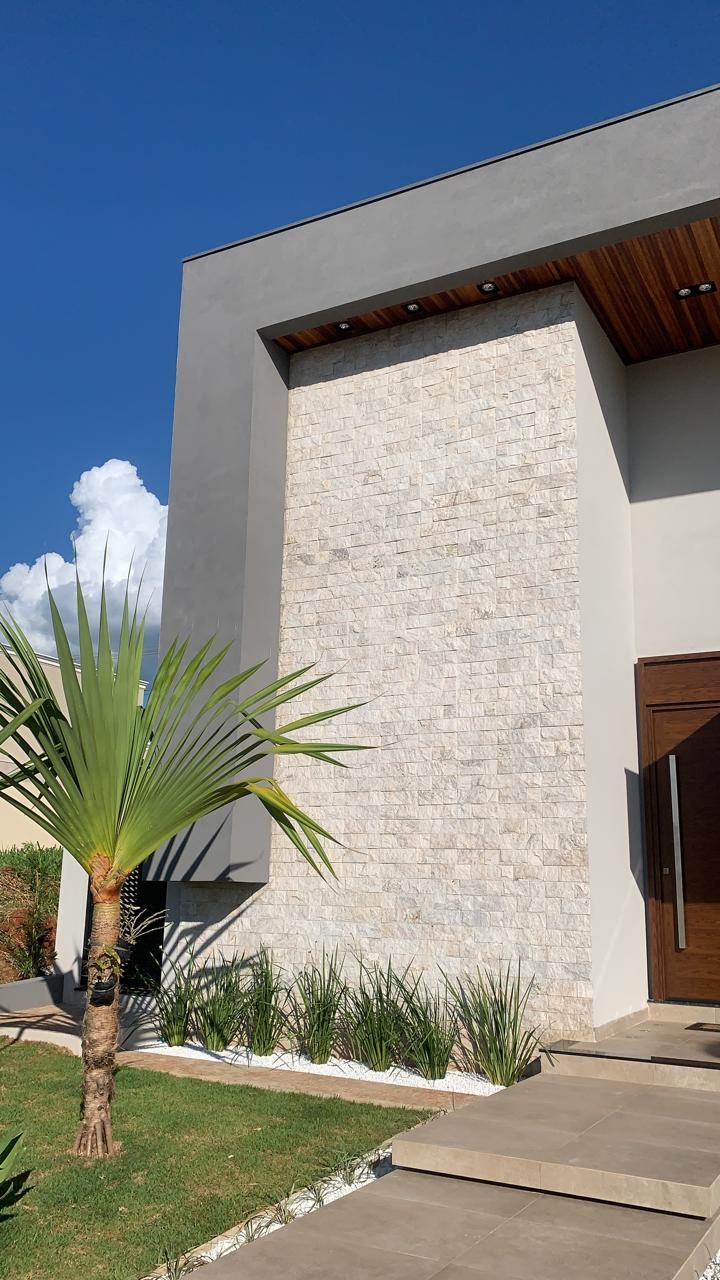Fachada de residência de alto padrão revestida em travertino rockface
